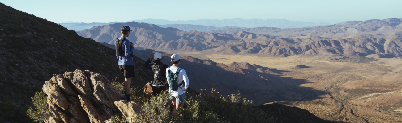 3 trail runners enjoying a scenic mountain vista